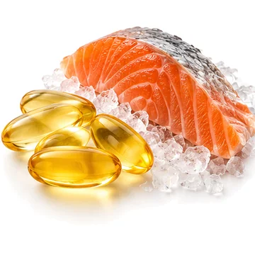 Golden fish oil softgels beside fresh salmon